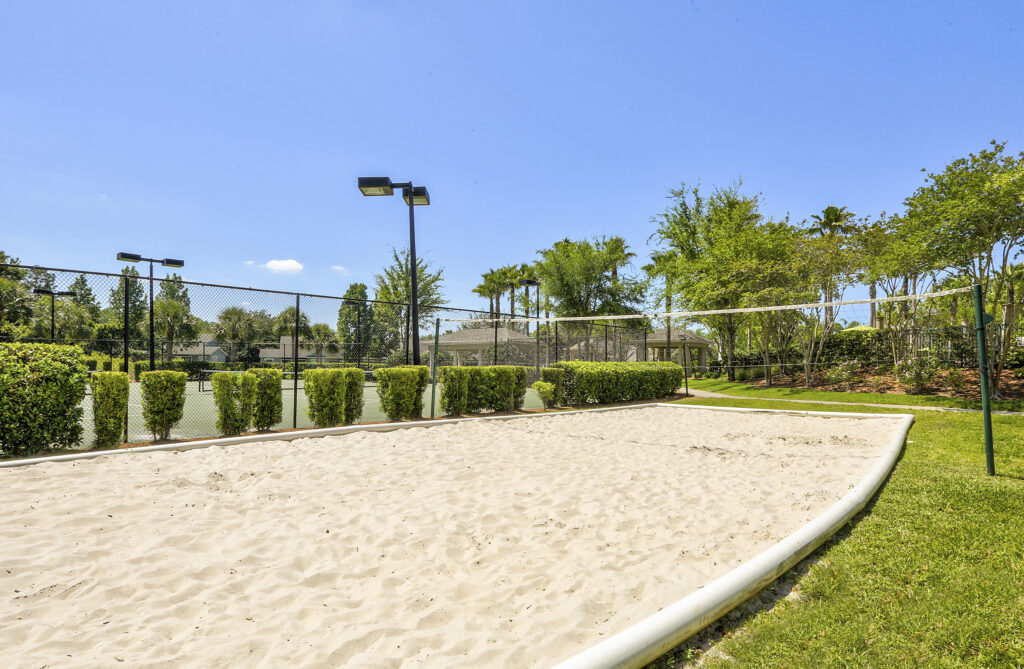 Sand volleyball court with trees and grass around