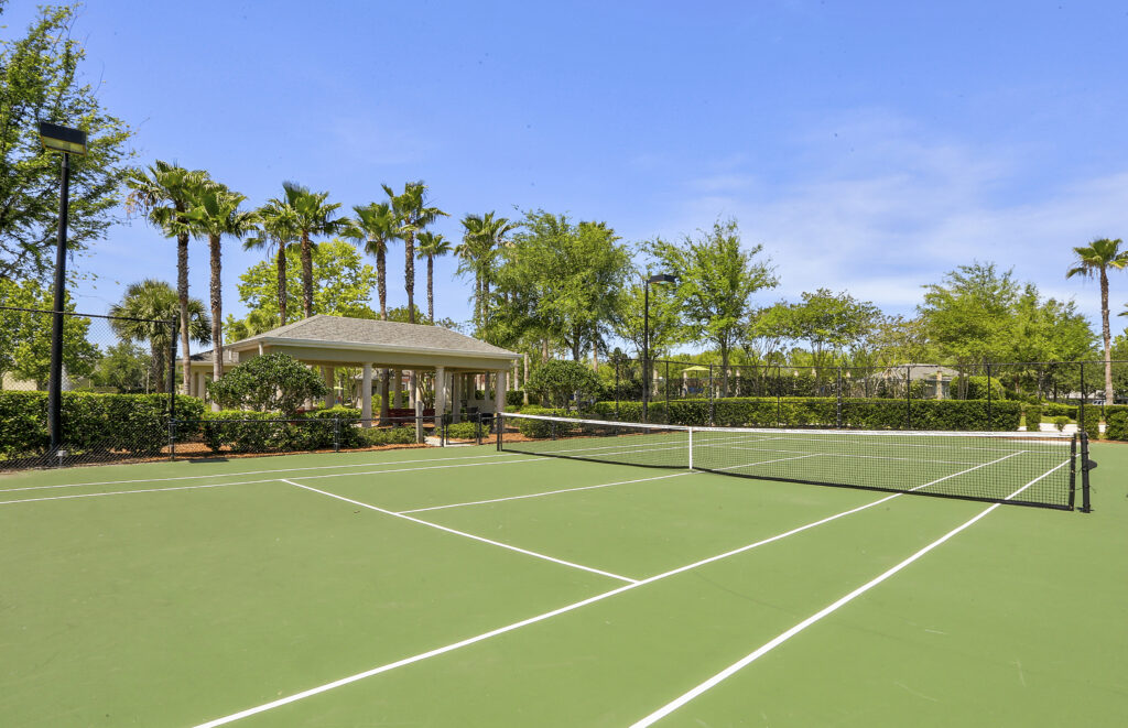 a tennis court with trees surrounding it