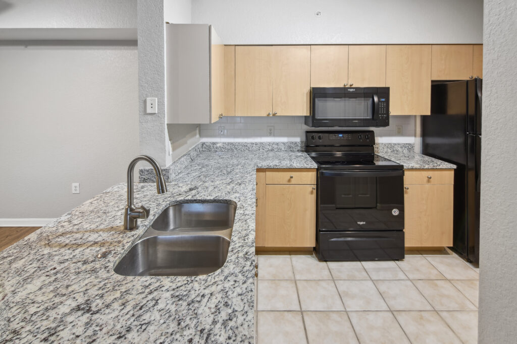 a kitchen with granite counter tops and black appliances