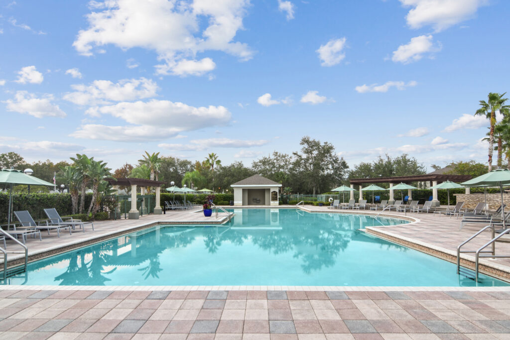 Large pool with deck seating and shade umbrellas