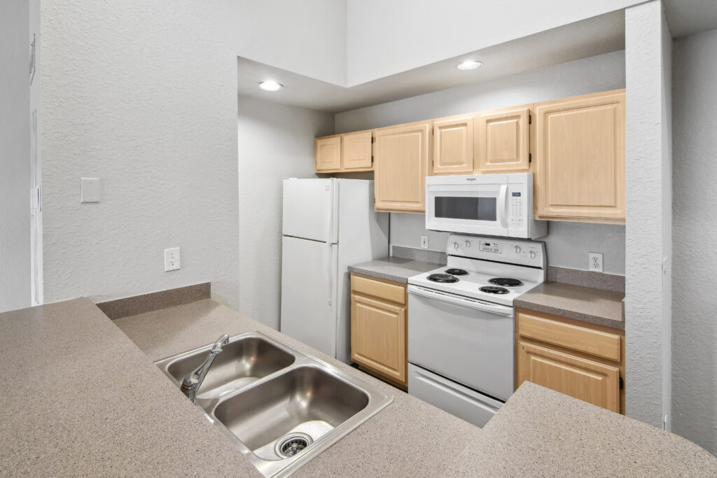 a kitchen with white appliances and wooden cabinets