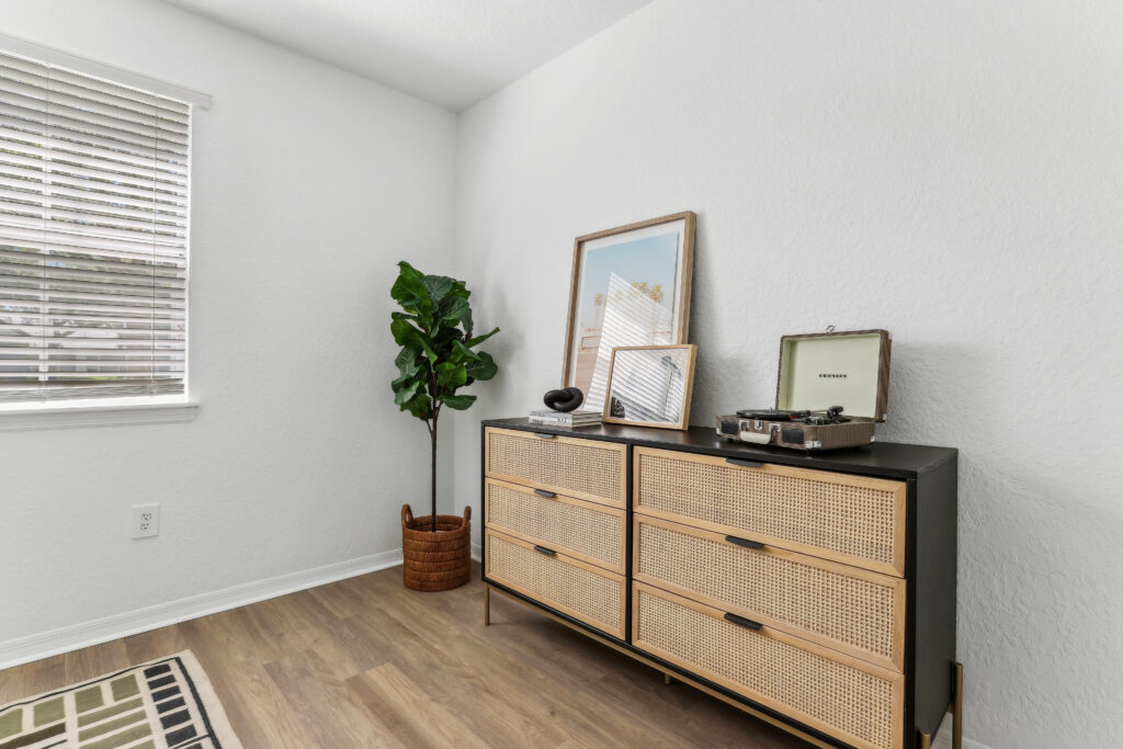 Bedroom with wood-style flooring, window, and clothes dresser