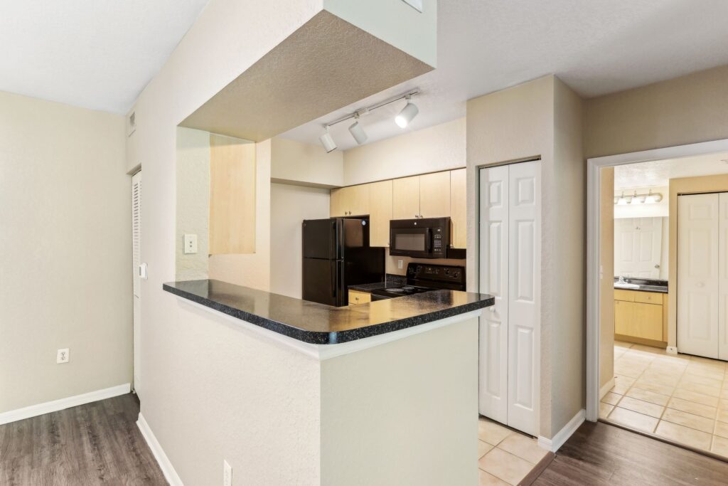 Kitchen with appliances, designer lighting, tile flooring and access to living room