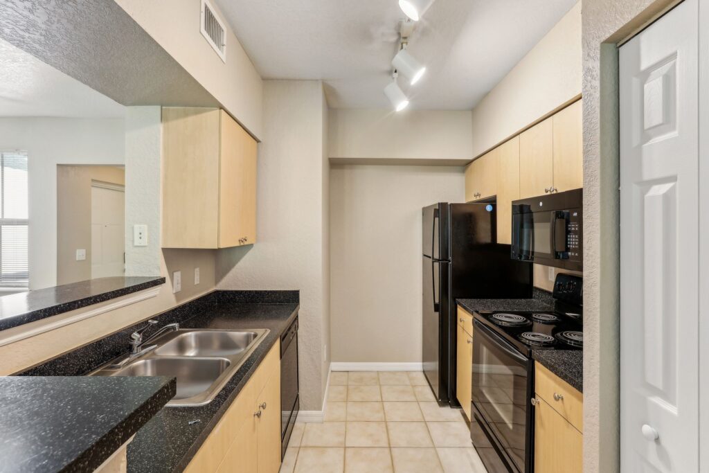 Kitchen with appliances, designer lighting, tile flooring and wood cabinets