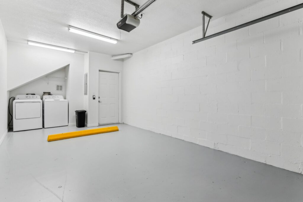Empty garage with designer lighting and washer and dryer