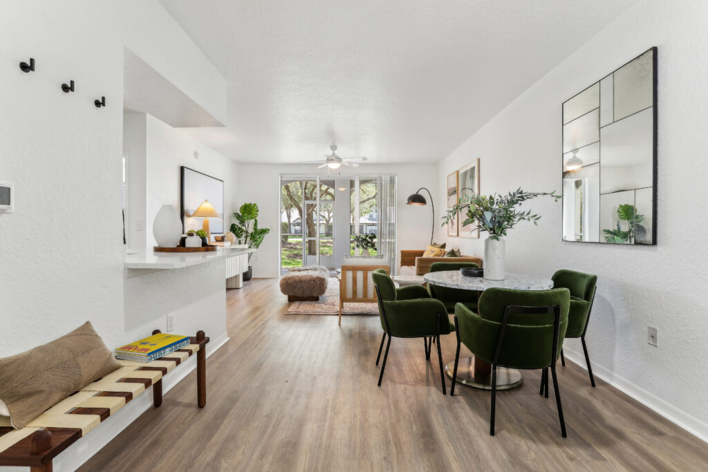 Dining room with table seating, wood-style flooring, designer lighting, and open access to the living room