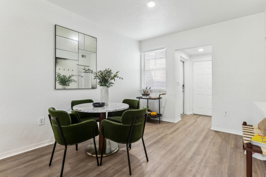 Dining room with table seating, wood-style flooring, and designer lighting